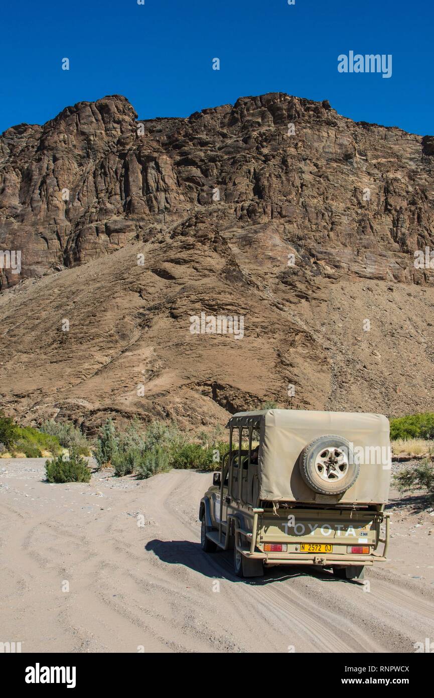 Jeep touristique conduisant par le sable profond à la recherche de safari, Khurab Réserver, le nord de la Namibie, Namibie Banque D'Images