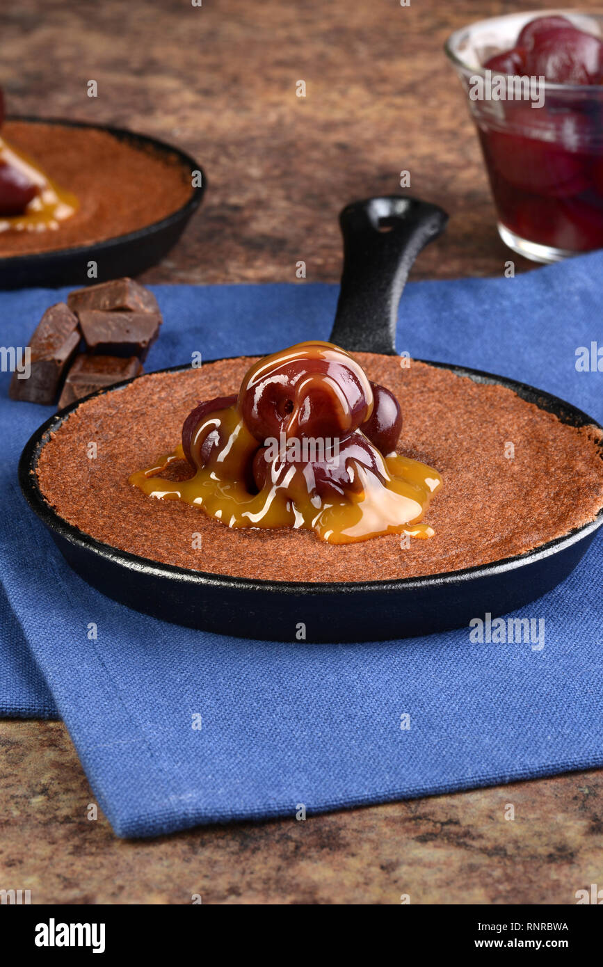 Casserole de gâteau au chocolat avec garniture de cerises Banque D'Images