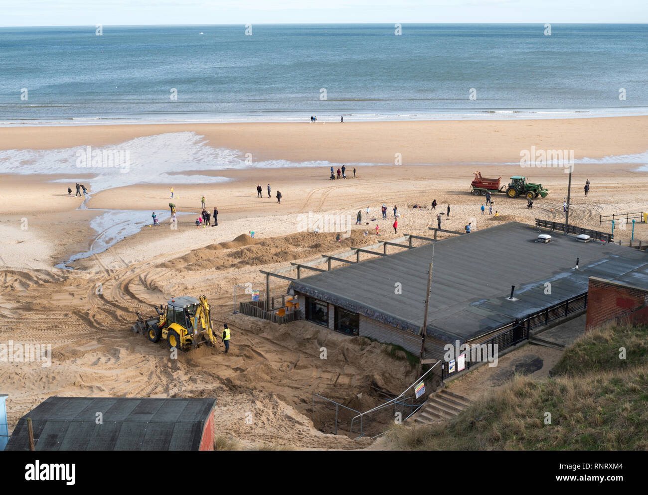 Les travailleurs utilisant redistribuer les tracteurs sur la plage de sable de Tynemouth, Angleterre du Nord-Est, Royaume-Uni Banque D'Images