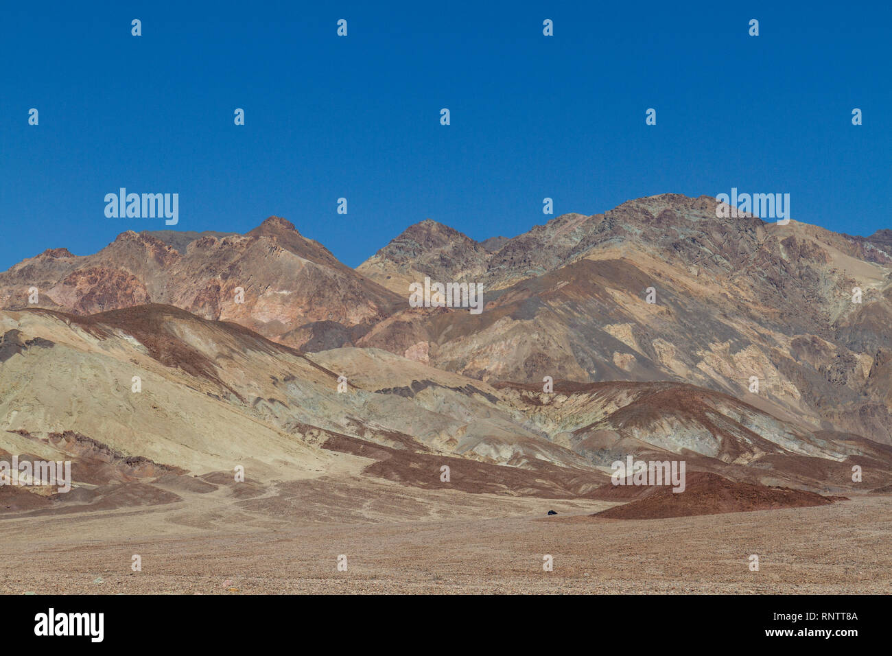 Une voiture (en bas à droite) à l'approche de la palette de l'artiste domaine de la vallée de la mort, Death Valley National Park, California, United States. Banque D'Images