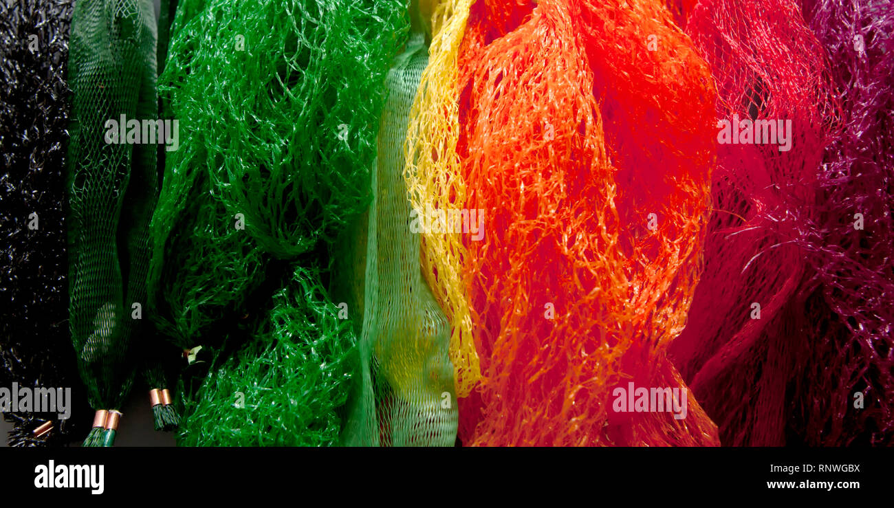 Un arc-en-ciel, l'éventail de fruits et légumes en plastique du type filets marqués 'pas encore' recyclé dans le Royaume-Uni, qui finissent dans les décharges ou dans l'océan Banque D'Images