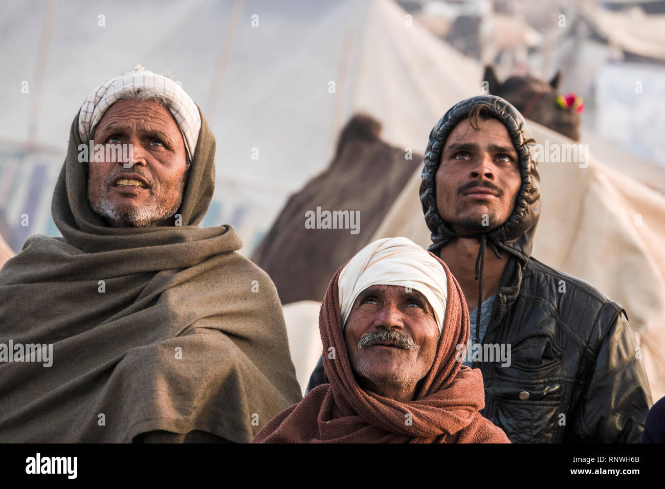Raika éleveurs de chameaux à regarder dans le ciel de drone à Pushkar Foire de chameau au Rajasthan, Inde Banque D'Images