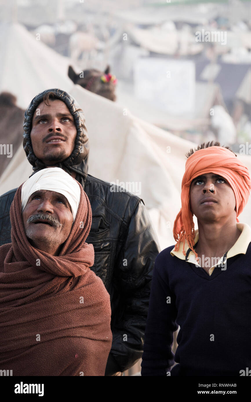 Raika éleveurs de chameaux à regarder dans le ciel de drone à Pushkar Foire de chameau au Rajasthan, Inde Banque D'Images