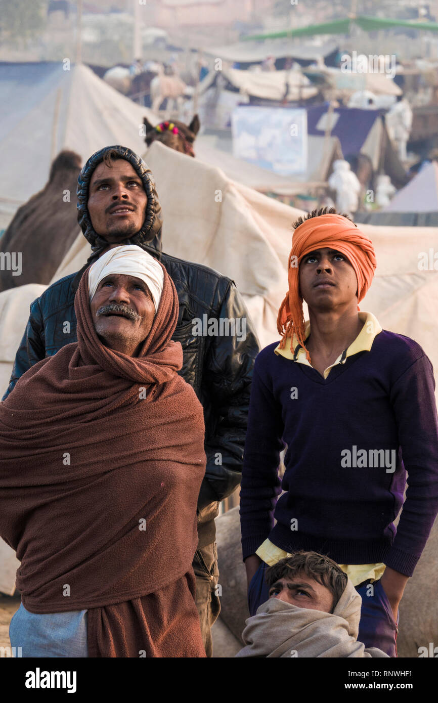 Raika éleveurs de chameaux à regarder dans le ciel de drone à Pushkar Foire de chameau au Rajasthan, Inde Banque D'Images