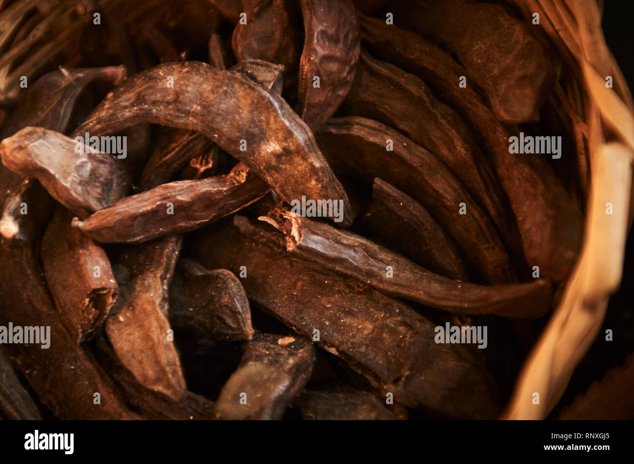 Une pile de tamarin séché dans un panier en vente dans une échoppe de marché à Dardara, Maroc. Banque D'Images