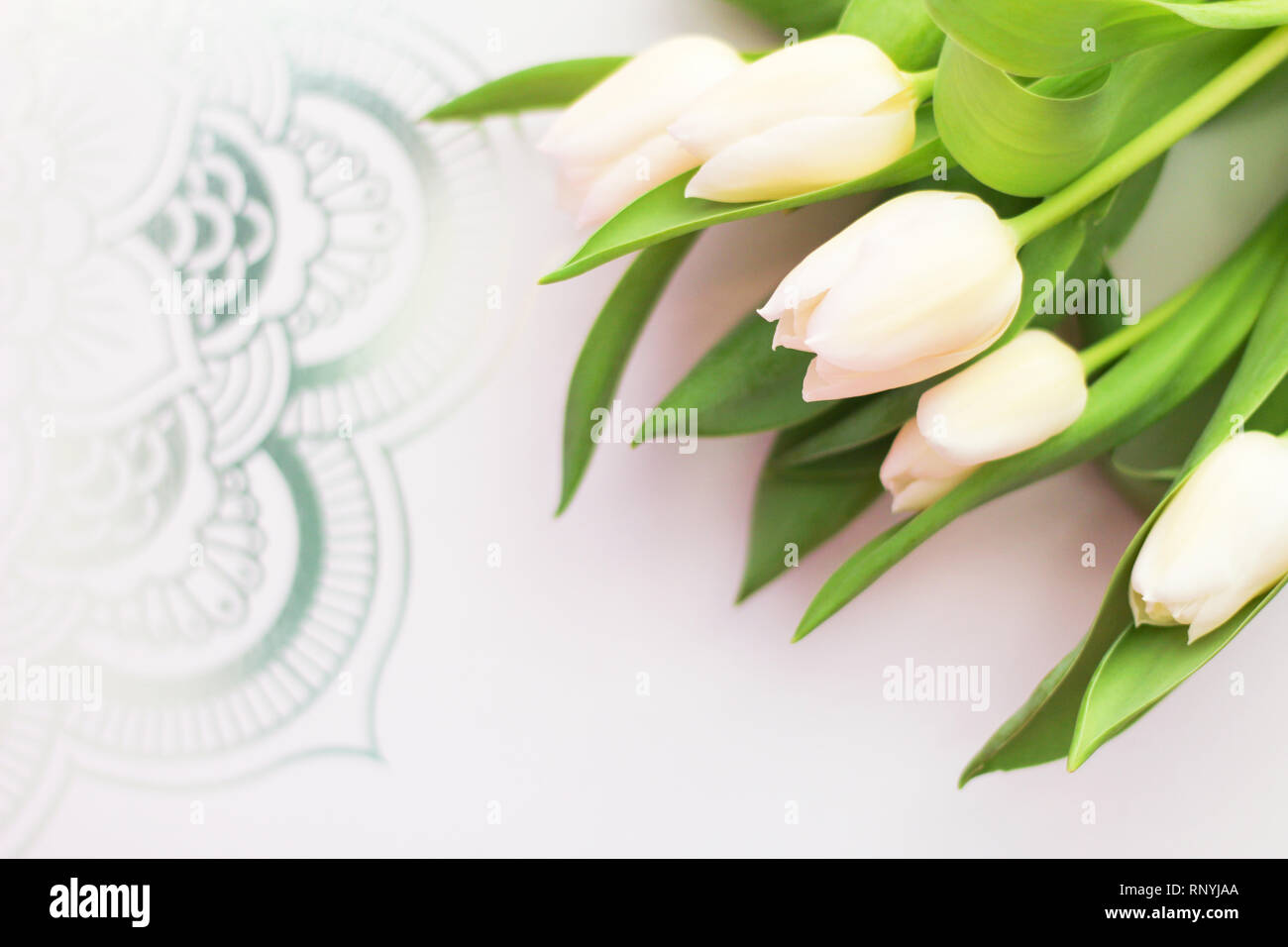 Décor élégant, parfait pour les médias sociaux pour les entreprises : tulipes blanches, fond blanc avec silver design, copie gratuite de l'espace, selective focus Banque D'Images