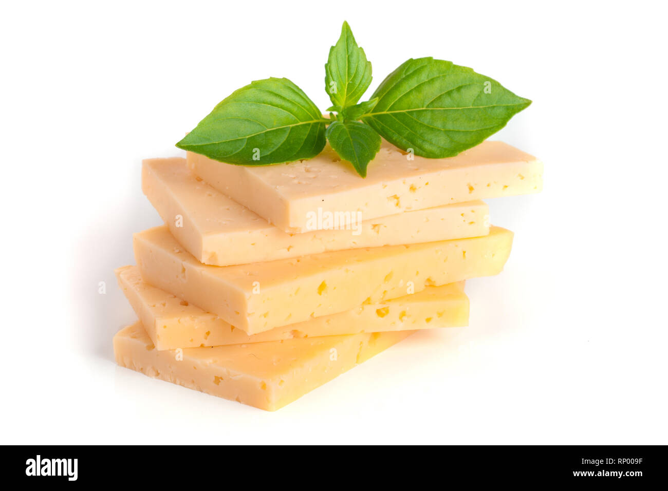 Le fromage avec des feuilles de basilic isolé sur fond blanc. Banque D'Images