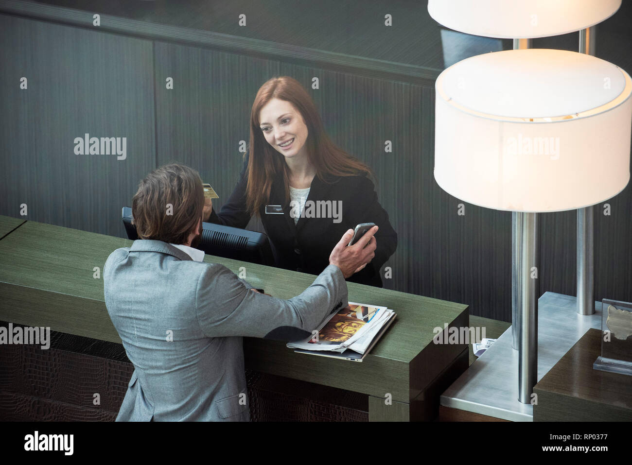Businessman showing smart phone à femme réceptionniste Banque D'Images