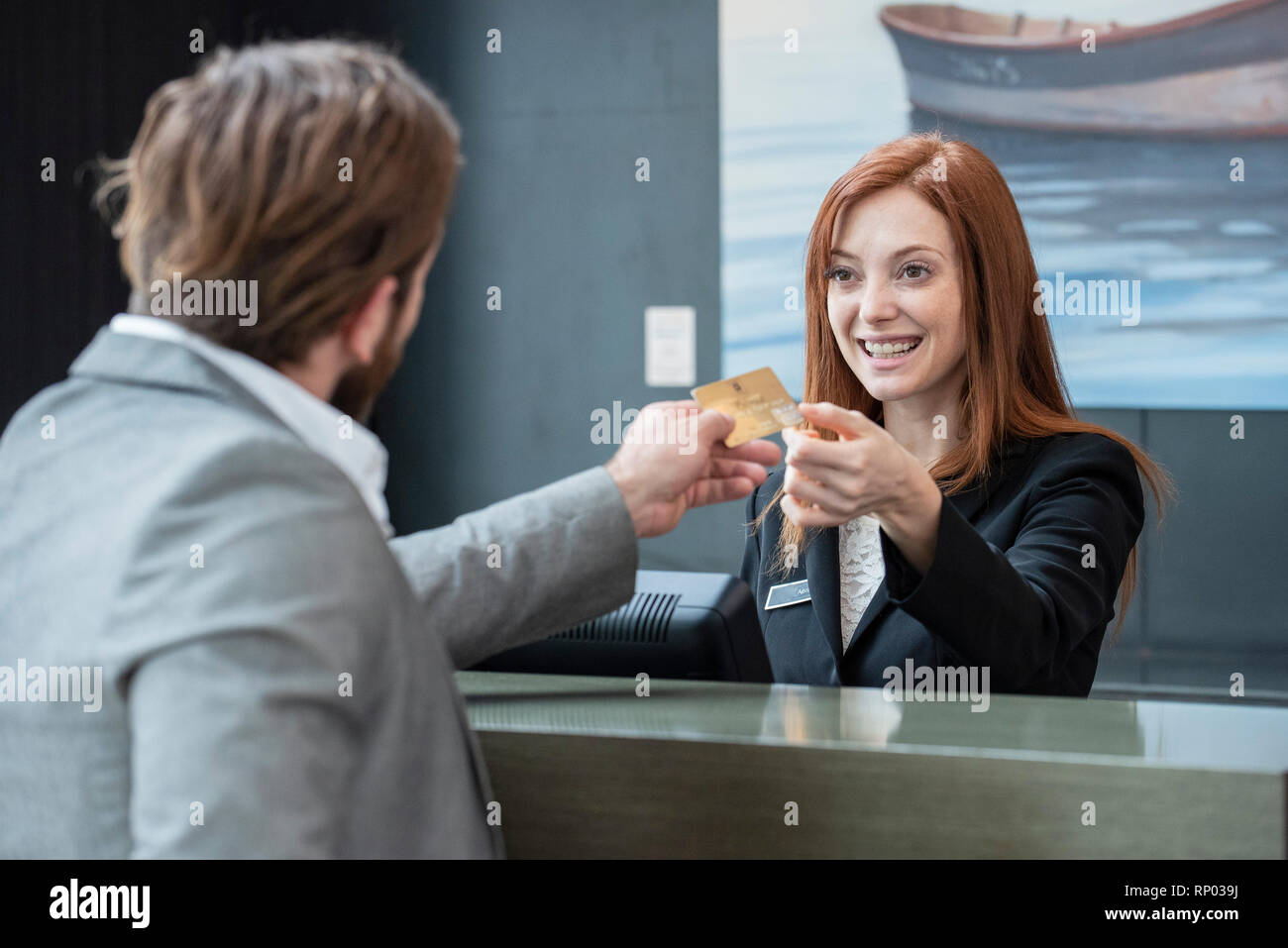 Businessman giving credit card to female réceptionniste Banque D'Images