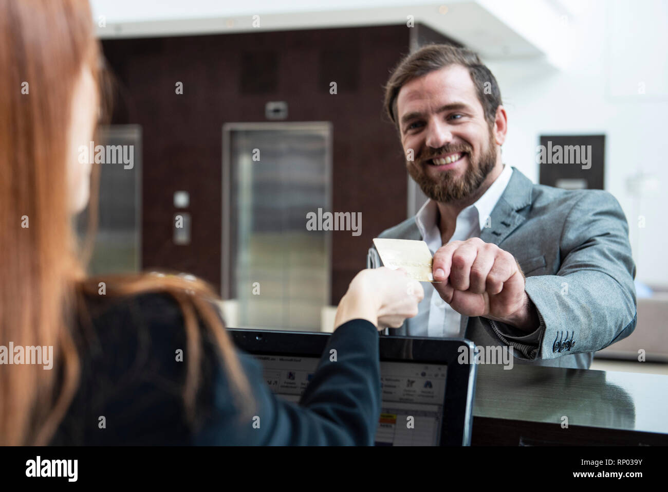 Businessman giving credit card to female réceptionniste Banque D'Images