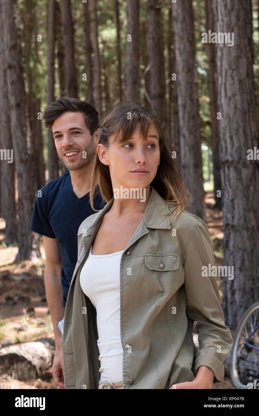 Jeune couple standing in forest Banque D'Images
