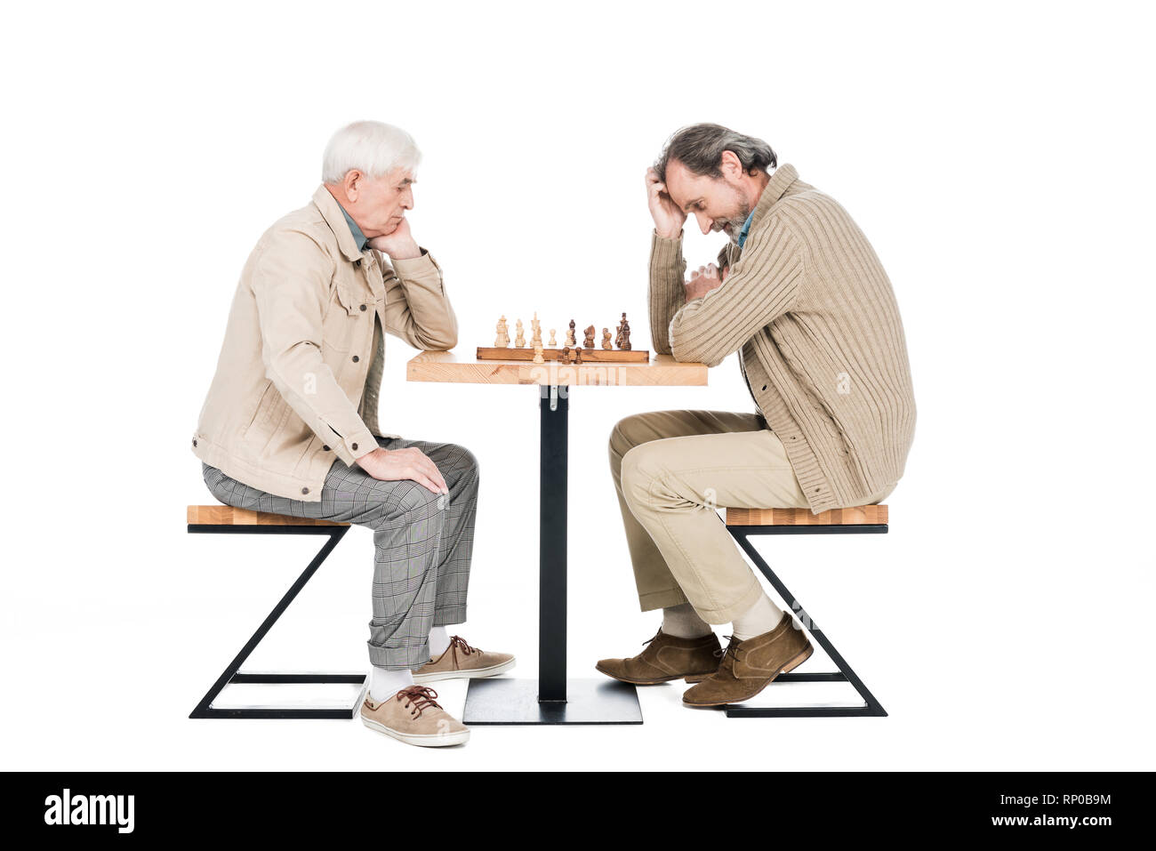 La pensée de l'homme à la retraite tout en jouant aux échecs avec ami isolated on white Banque D'Images
