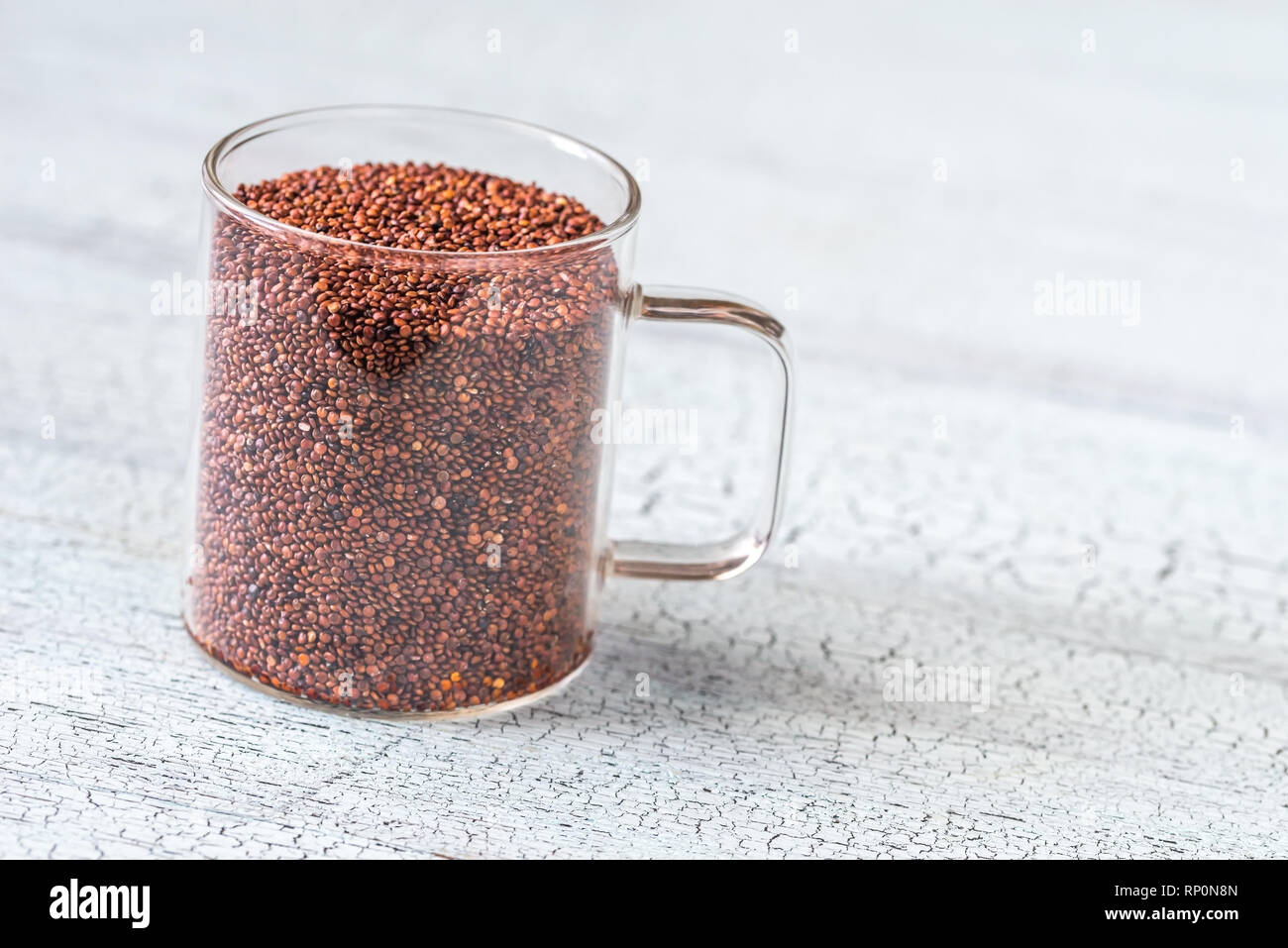 Tasse en verre de quinoa rouge sur le fond de bois Banque D'Images