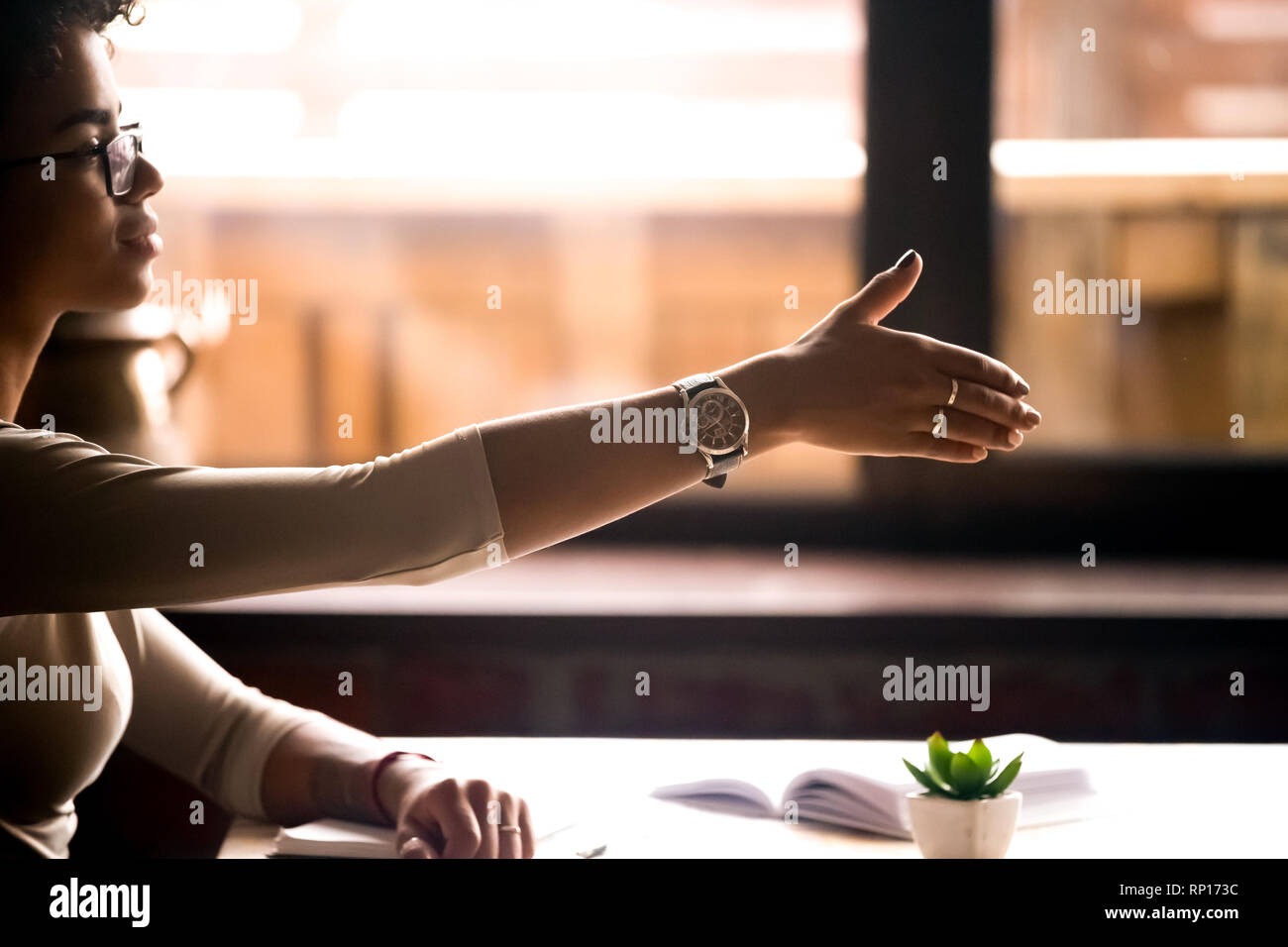Femme assise à table contient ses hand for handshake Banque D'Images