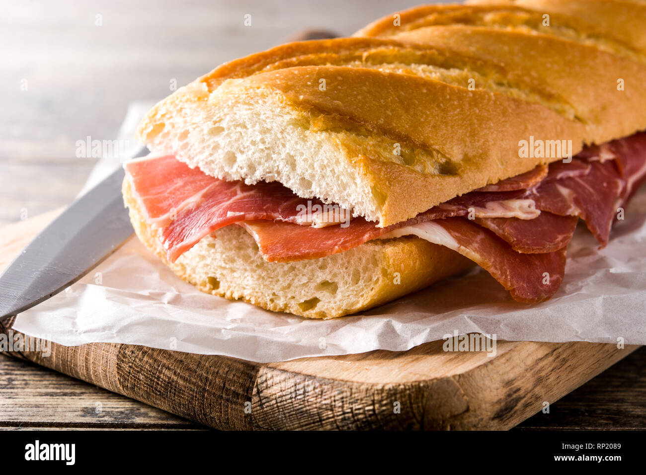 Sandwich au jambon serrano espagnol sur table en bois Banque D'Images
