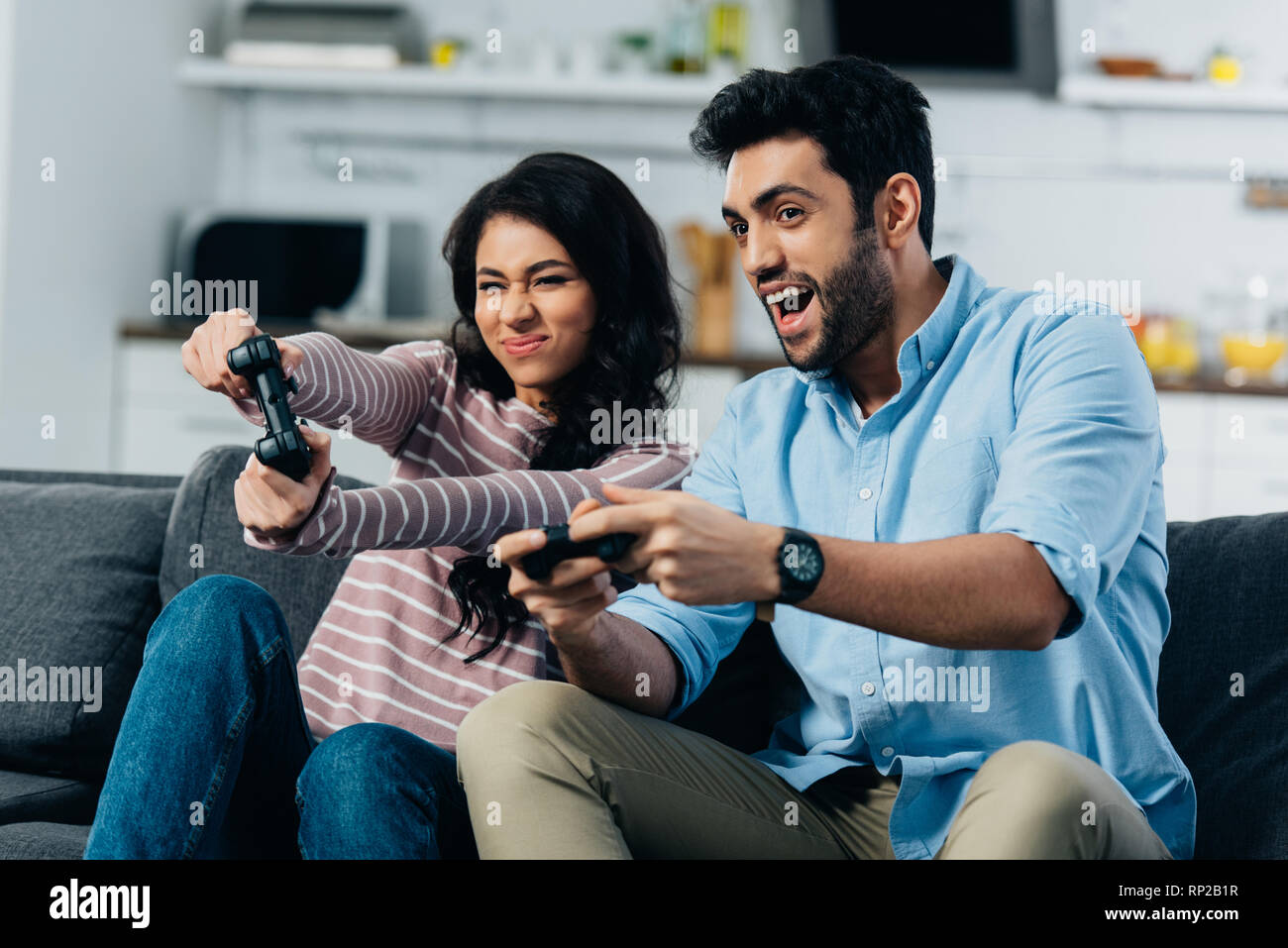 Beau l'homme jouant de jeu vidéo avec femme à la maison Banque D'Images