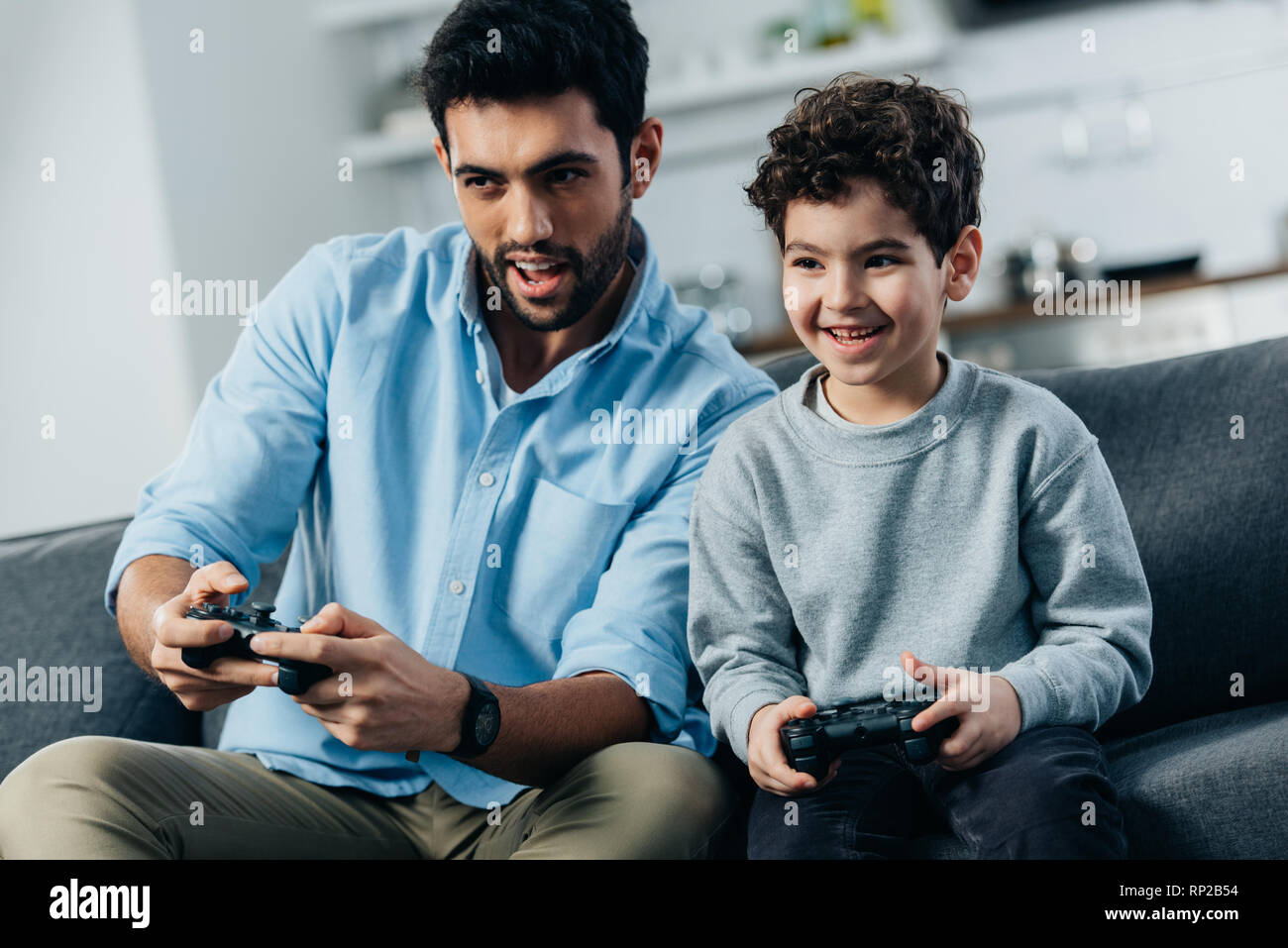 Cheerful Amérique father and son playing video game at home Banque D'Images