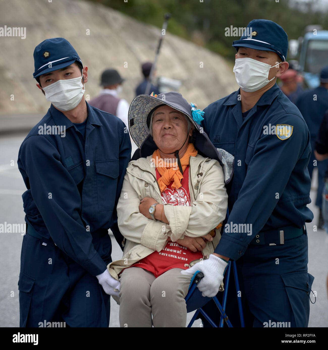 Henoko, Okinawa, Japon. Feb 19, 2019. Police effectue une femme loin de la porte d'une nouvelle base aérienne du Corps des Marines des États-Unis en voie de construction à Henoko sur l'île japonaise d'Okinawa. Des dizaines de manifestants, qui veulent l'arrêt de la construction, a dû être physiquement retirée pour que les camions de remplir pour entrer dans la base, qui est de pourvoir à une énorme partie de la mer afin de construire une nouvelle base. Photo : Paul Jeffrey/Alamy Live News Banque D'Images