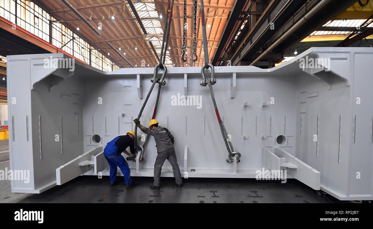 Erfurt, Allemagne. Feb 20, 2019. Deux employés fixer le composant d'une grande presse à la grue dans un hall de production de Schuler Pressen GmbH. Selon Schuler, c'est le plus grand fabricant du monde de la technologie de formage et de fournitures presses pour la production de parties du corps et des pièces, ainsi que des machines pour la construction de tubes de grand diamètre et de matériel ferroviaire. Depuis 2013, le Groupe a fait partie de l'Autrichien Andritz groupe génie mécanique et emploie actuellement environ 6600 personnes, 560 d'entre eux d'Erfurt. Crédit : Martin Schutt/dpa-Zentralbild/dpa/Alamy Live News Banque D'Images