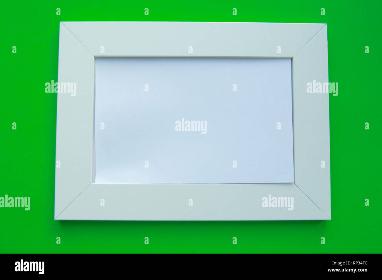 Cadre blanc vide avec espace pour texte se trouve sur un fond vert. Banque D'Images
