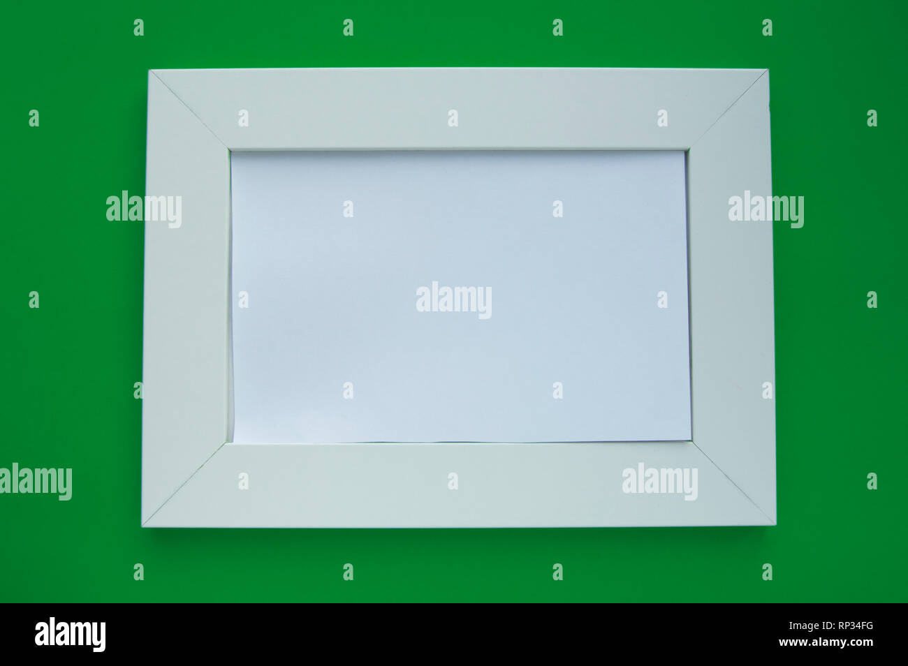 Cadre blanc vide avec espace pour texte se trouve sur un fond vert. Banque D'Images