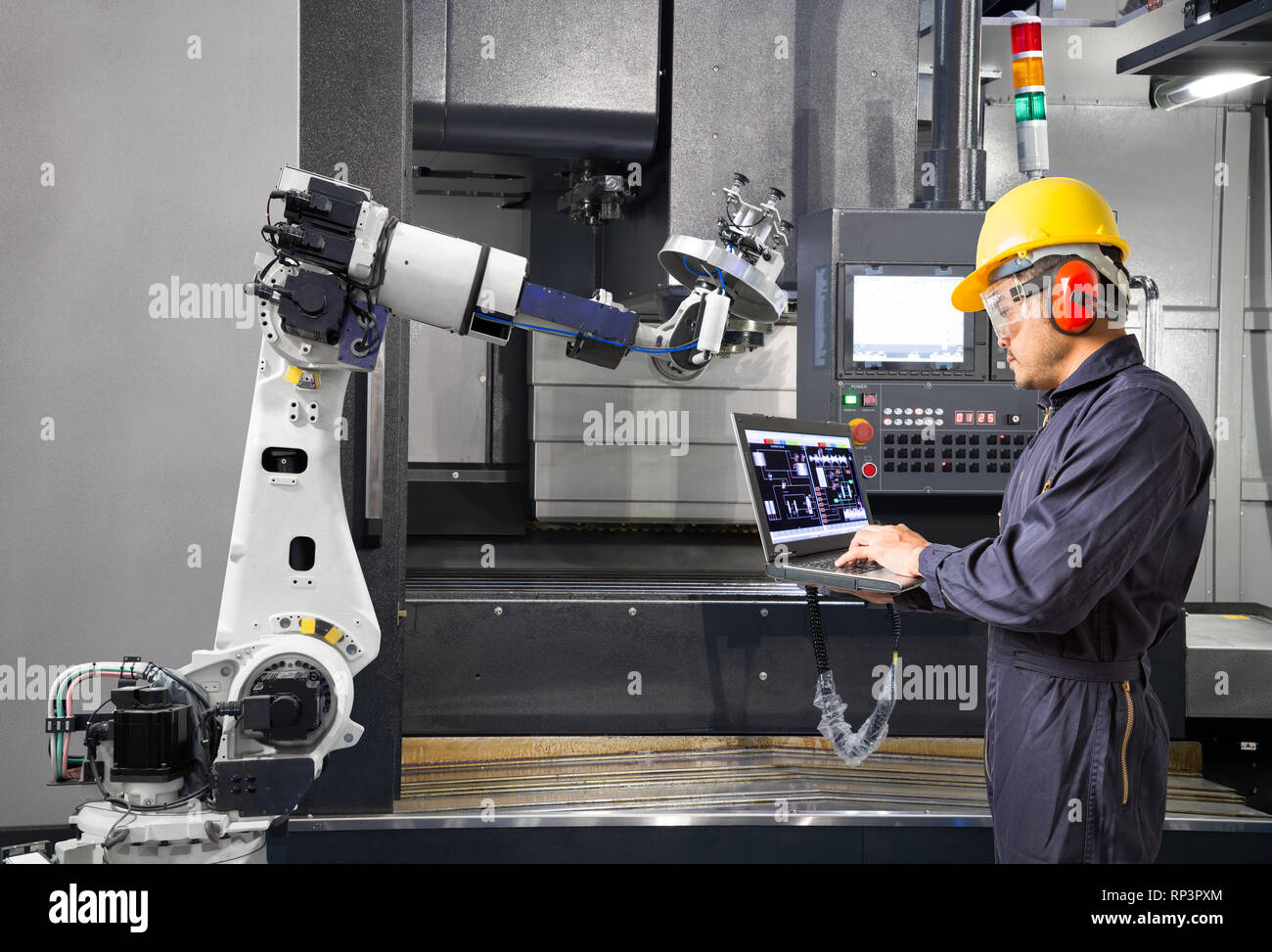 Ingénieur de maintenance en utilisant un ordinateur portable contrôle automatique main robotique avec machine CNC dans smart factory. 4.0 Concept de l'industrie Banque D'Images