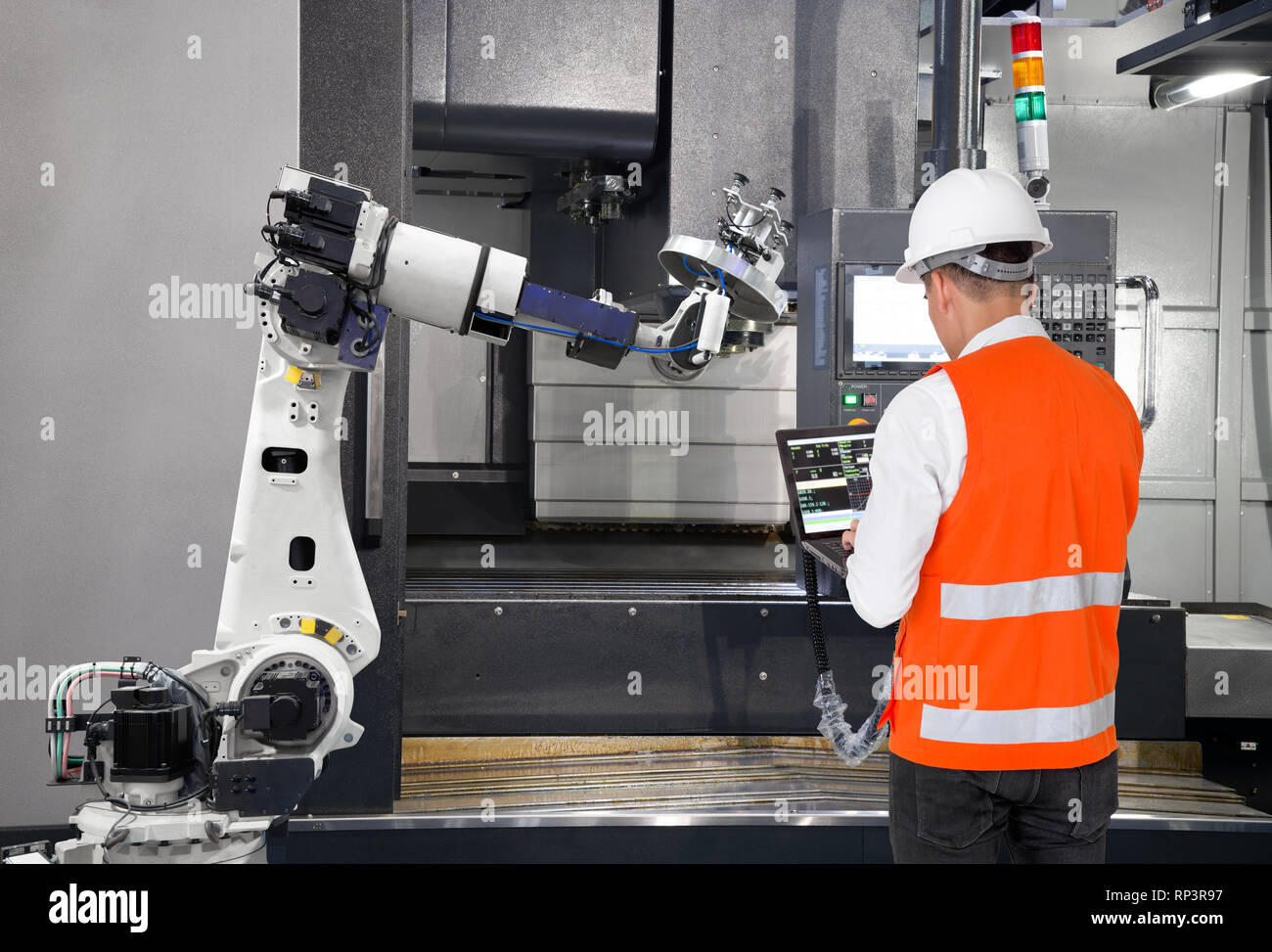 Ingénieur de maintenance en utilisant un ordinateur portable contrôle automatique main robotique avec machine CNC dans smart factory. 4.0 Concept de l'industrie Banque D'Images