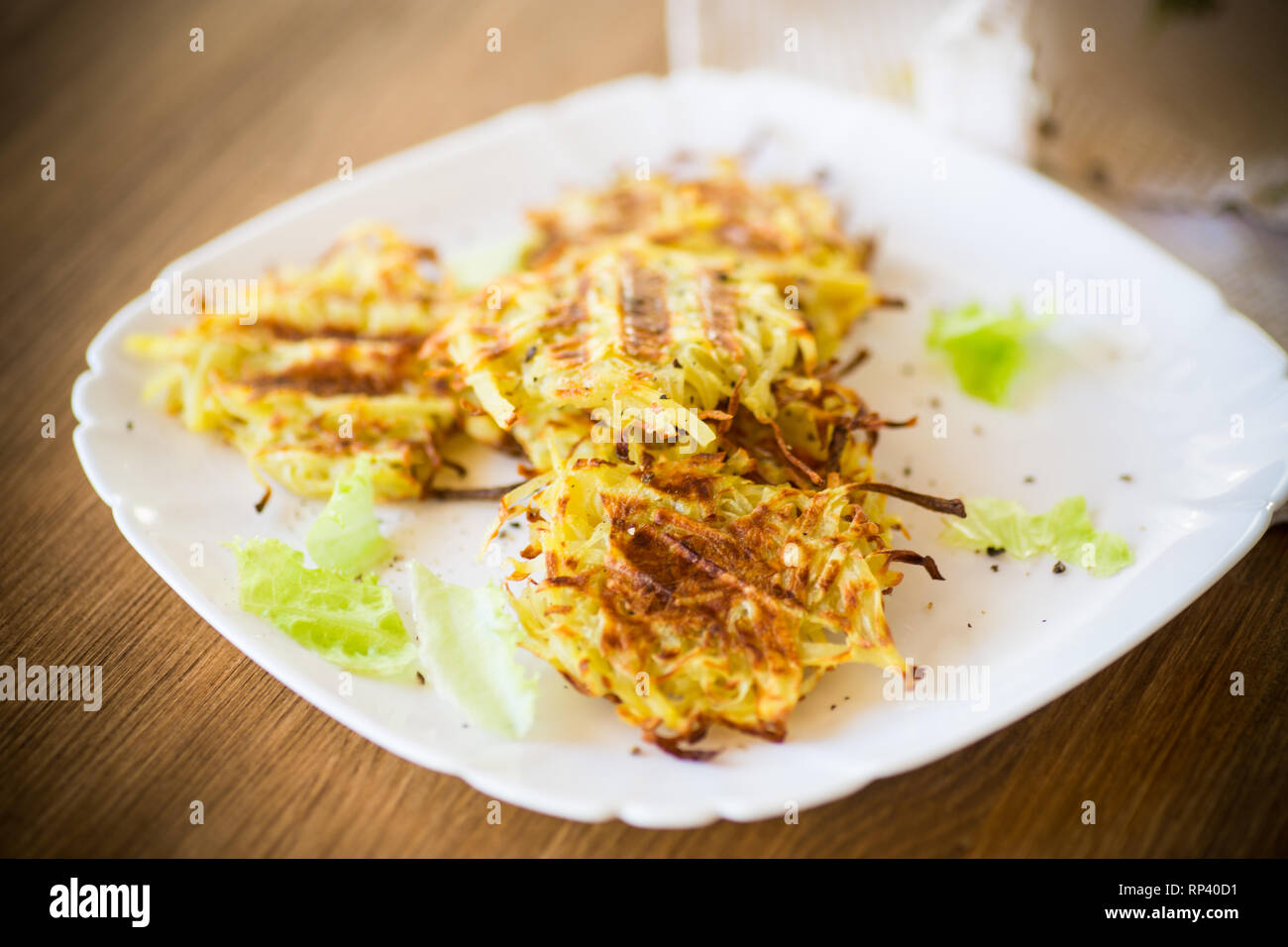 Les galettes de pommes de terre grillées dans une assiette sur une table en bois Banque D'Images