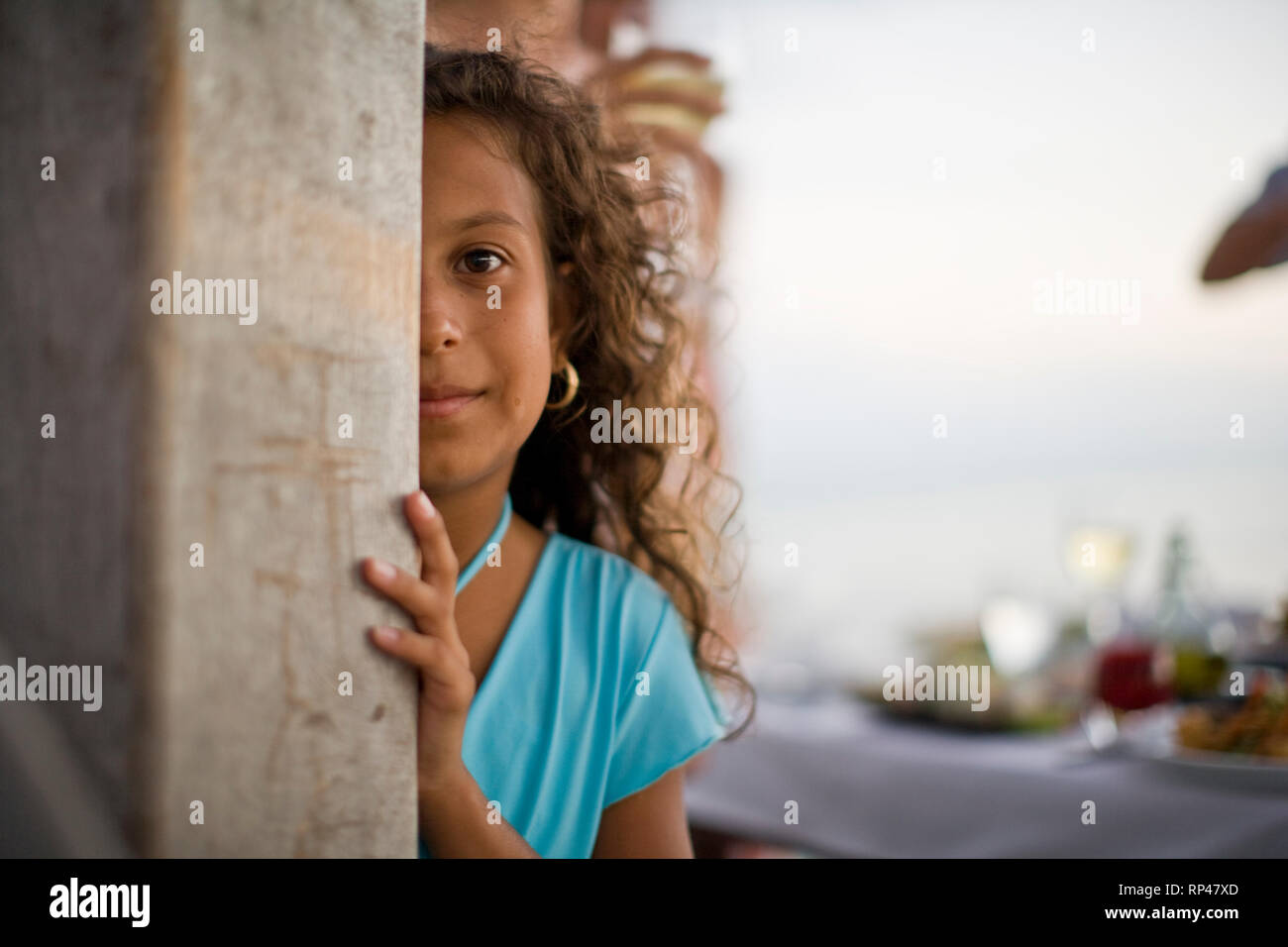 Portrait d'une jeune fille se cacher derrière un poteau. Banque D'Images