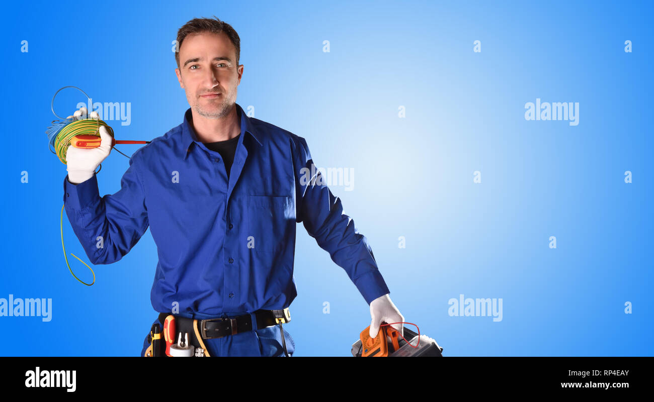 Avec l'arrière-plan avec des outils d'électricien en uniforme et l'équipement électrique et le fond bleu. Vue de face. Moitié du corps Banque D'Images