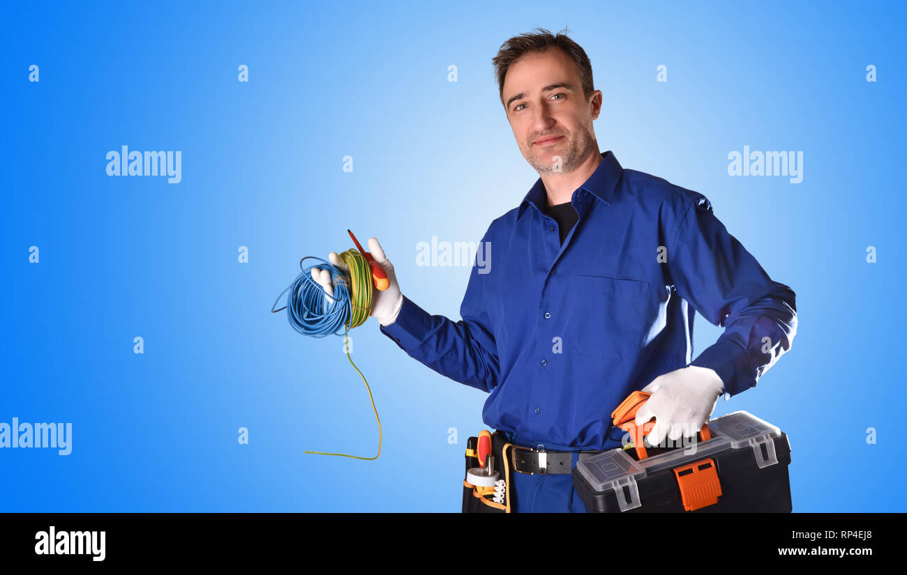 Avec l'arrière-plan avec des outils d'électricien en uniforme et l'équipement électrique et le fond bleu. Vue de face. Moitié du corps Banque D'Images