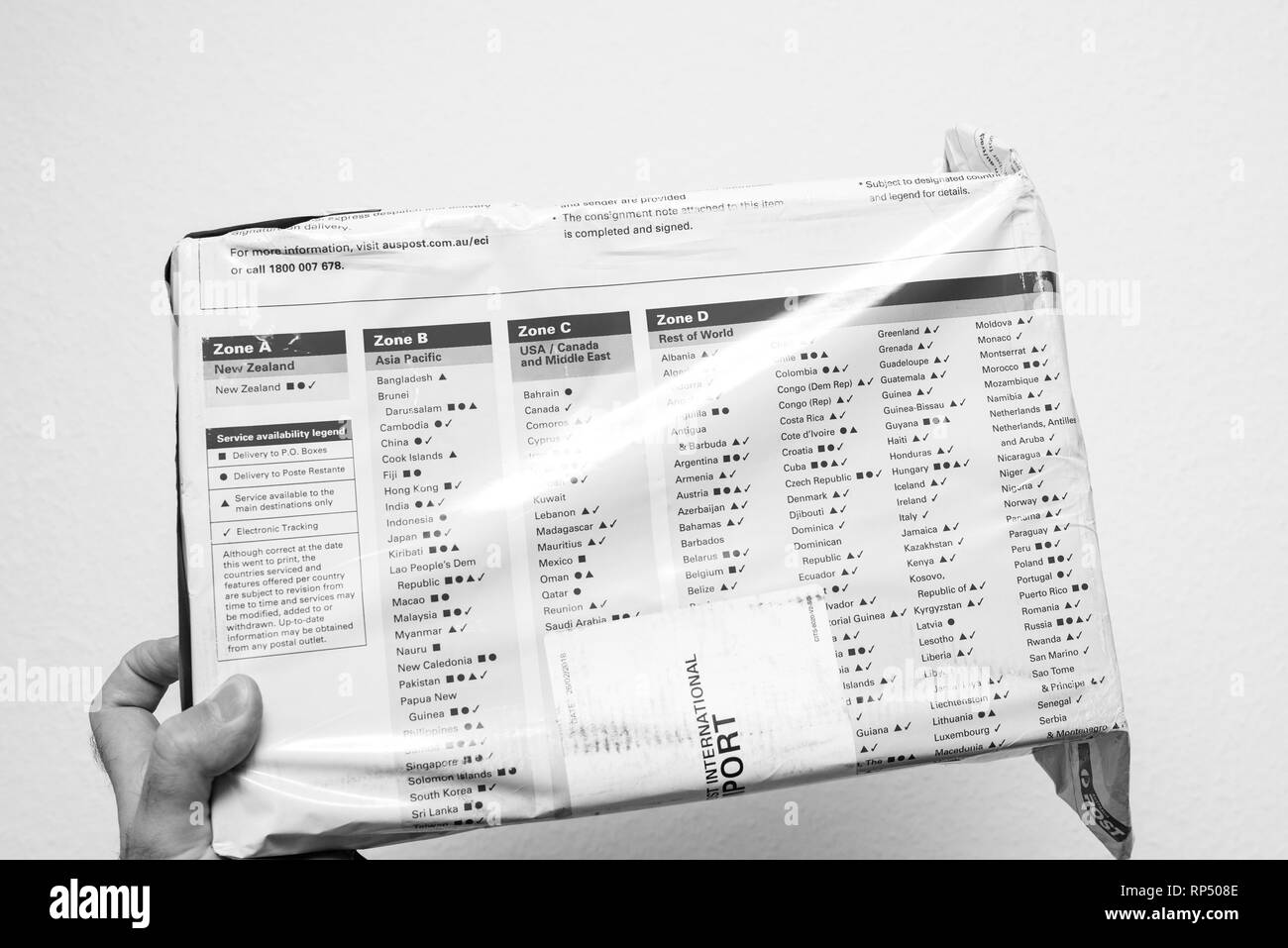 Londres, UK - DEC 27, 2018 : Man hand holding Australie Après EMS colis Colis poste reçu par mail - grande boîte shopping livraison livraison pays worldwidediverse zones internationales Banque D'Images