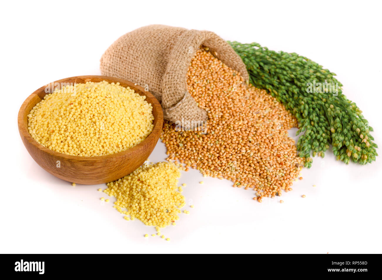 Millet dans un bol en bois, sac de toile et d'épillets vert isolé sur fond blanc. Banque D'Images