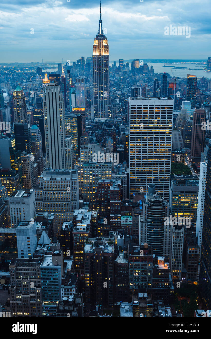 Les changements de rythme de la ville de New York comme des lumières en aléatoire illuminer fenêtres de bureau au crépuscule Banque D'Images
