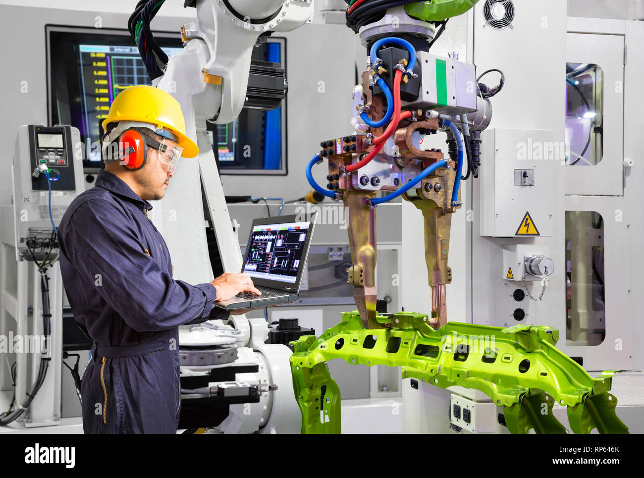 Ingénieur de maintenance en utilisant un ordinateur portable poignée robot de contrôle de pièce dans l'automobile, l'industrie de l'usine smart concept 4.0 Banque D'Images