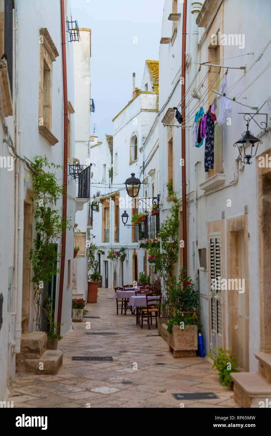 Rue blanche étroite et tables de restaurant dans la vieille ville, province Bari Bari, région Puglia, Italie sauthern Banque D'Images
