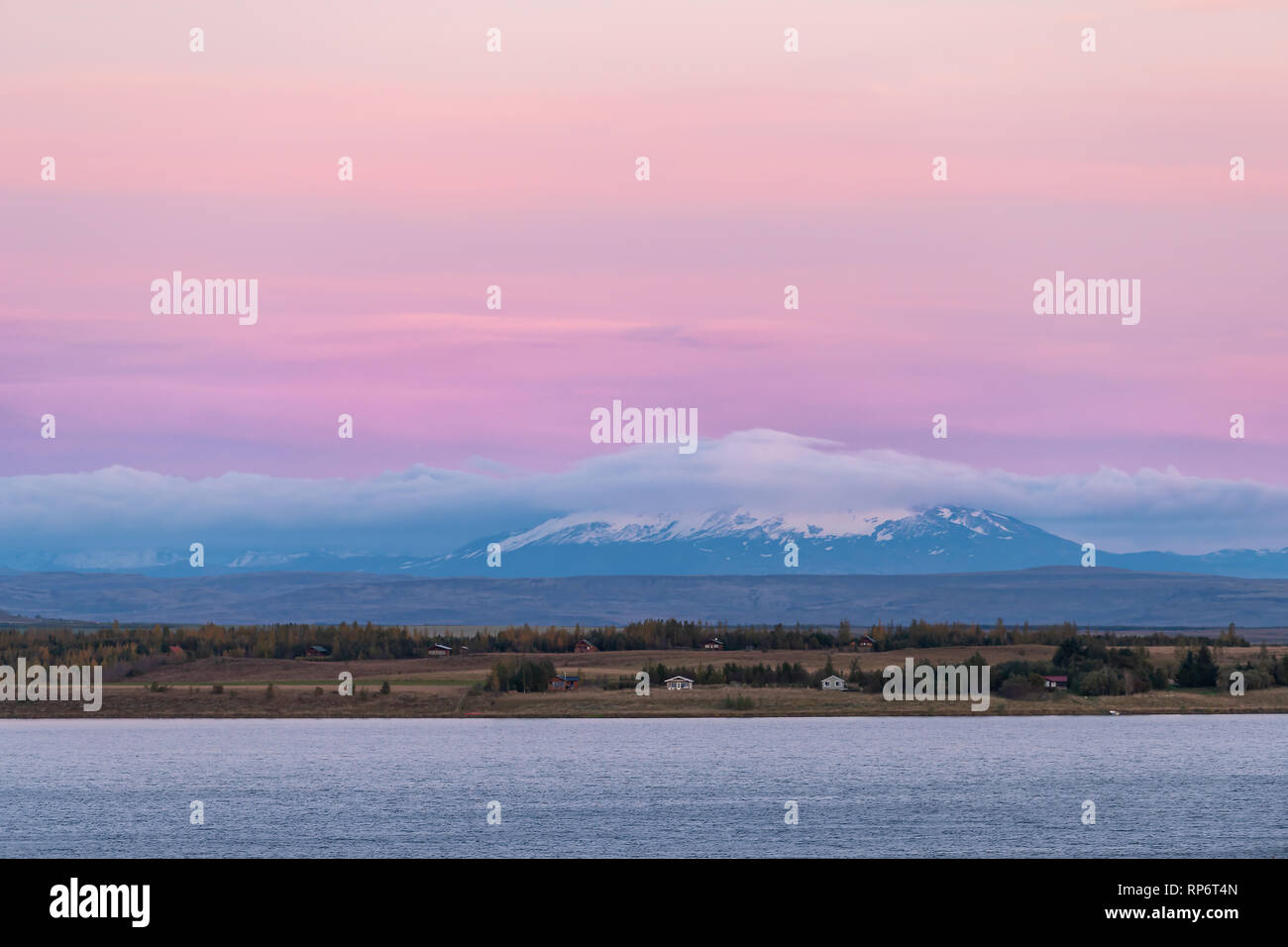 L'antenne paysage portrait de l'eau du lac Laugarvatn sur cercle d'or en Islande avec des maisons de ferme dans le lointain village pendant le crépuscule rose et bleu Banque D'Images