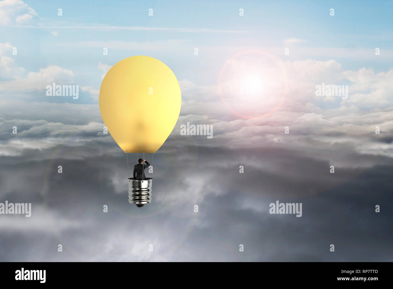 En homme d'ampoule jaune brillant hot air balloon flying over natural daylight sky background cloudscape Banque D'Images