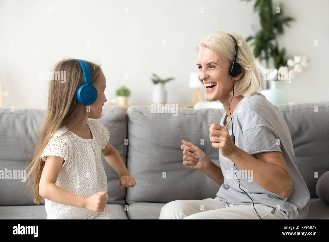 Heureux grand-mère avec sa petite-fille dans les écouteurs pour écouter de la musique Banque D'Images