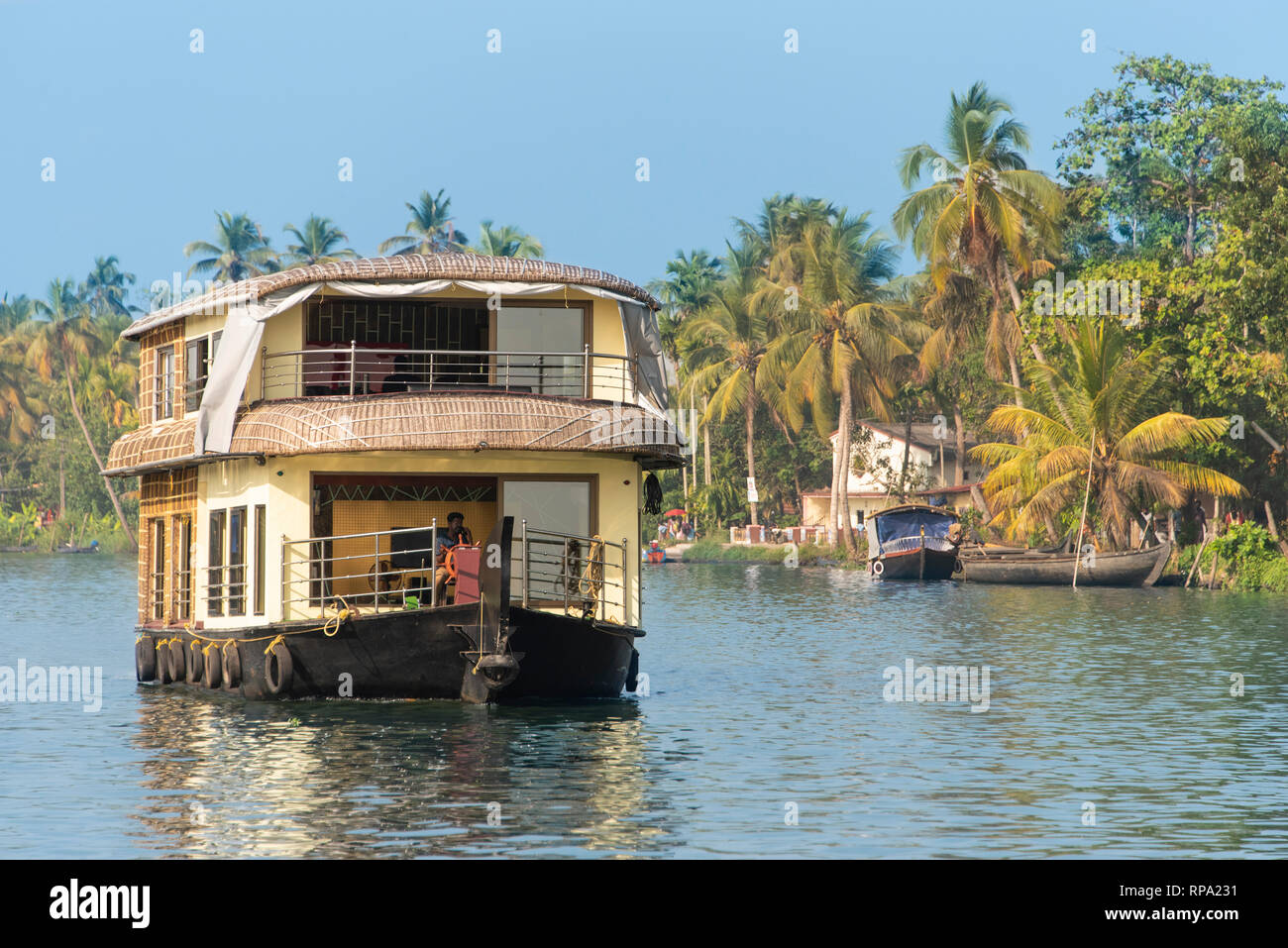 Un exemple typique d'une journée de croisière en bateau traditionnel flottant sur l'eau dormante Keralan lors d'une journée ensoleillée avec ciel bleu et de palmiers. Banque D'Images