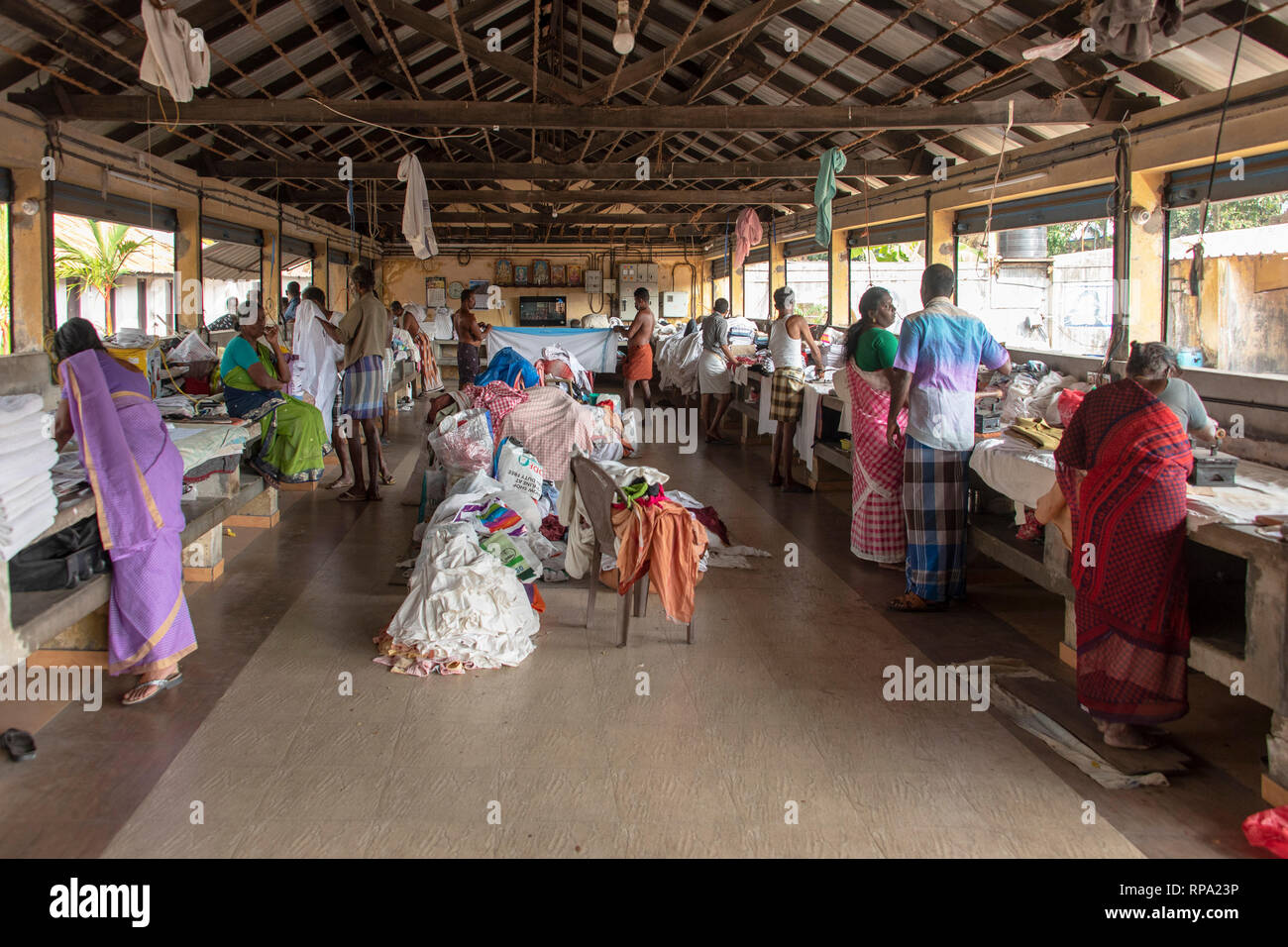 Les travailleurs qui travaillent au repassage blanchisserie publique Dhobi khana à fort Kochi. Banque D'Images