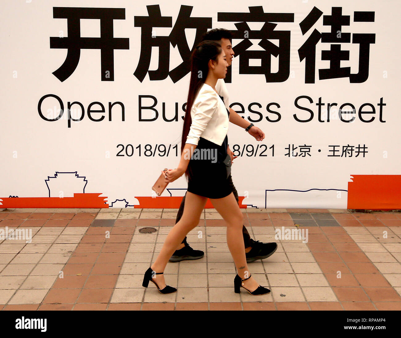 Beijing, Chine. 19 Sep, 2018. Chinese passons un peu de temps à ouvrir une entreprise commerciale internationale street à Pékin le 19 septembre 2018. La Chine a annoncé cette semaine les tarifs douaniers sur les marchandises des États-Unis d'une valeur de 60 milliards de dollars en représailles à la décision du Président Donald Trump d'imposer des droits sur 200 milliards de produits chinois que la guerre commerciale entre les deux plus grandes économies du monde s'intensifie. Credit : Todd Lee/ZUMAprilESS.com/ZUMA Wire/Alamy Live News Banque D'Images