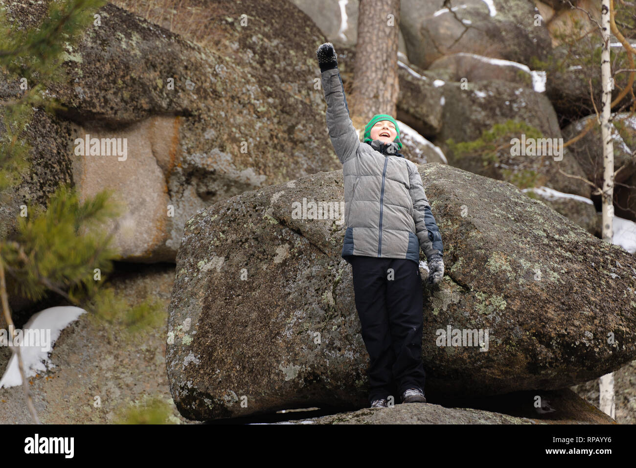 Le garçon monta sur un rocher au milieu des rochers. Journée d'hiver. Réserver Stolby, Krasnoïarsk, en Sibérie, en Russie. Banque D'Images