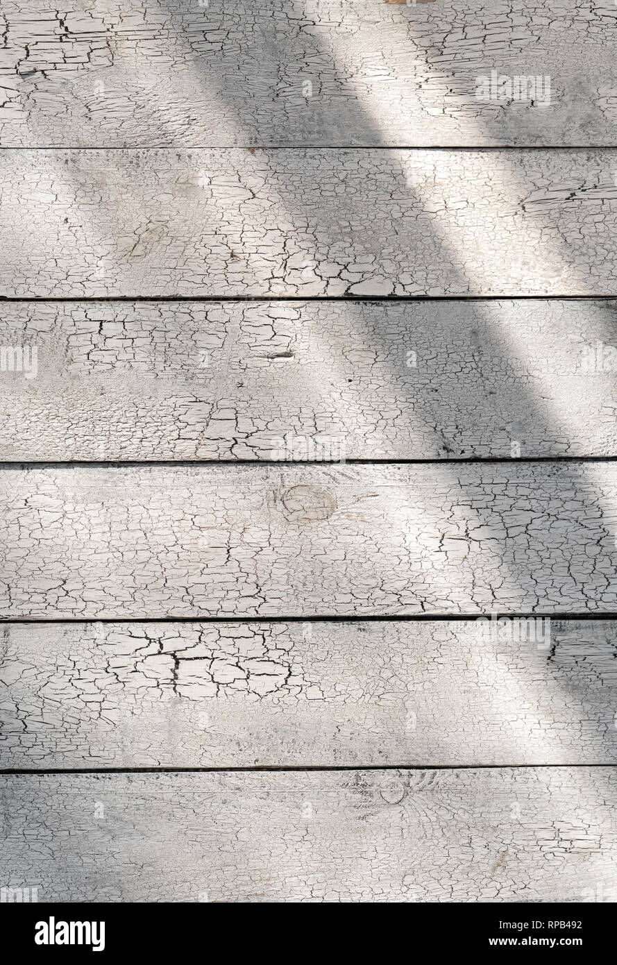 Peinture craquelée blanche sur fond de bois rustique avec des planches minable du soleil Banque D'Images
