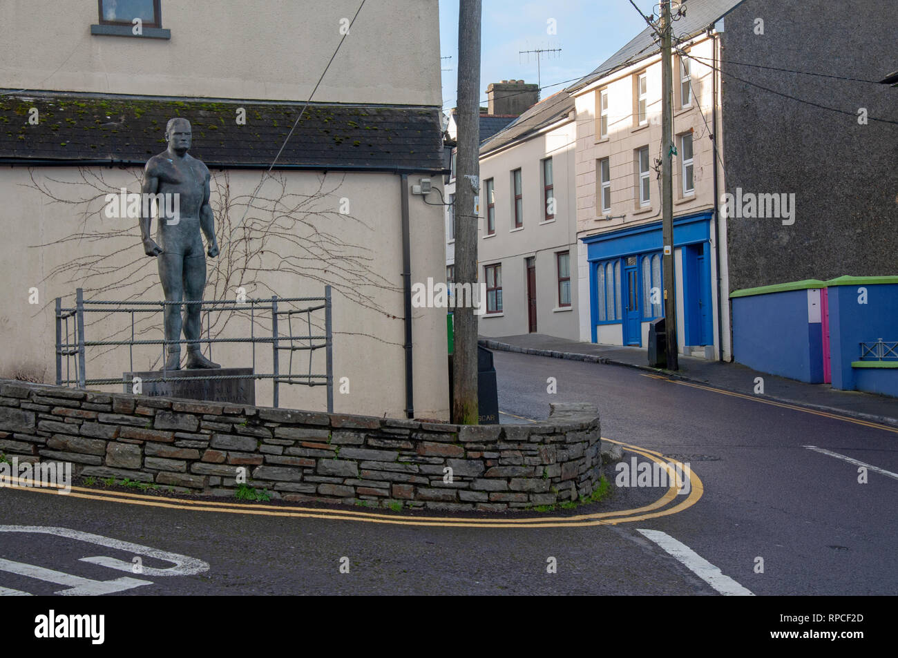 La statue de bronze de héros local et world champion de lutte 'Danno' O'Mahony, donne de l'autre côté de la rue principale de Ballydehob, West Cork, Irlande. Banque D'Images