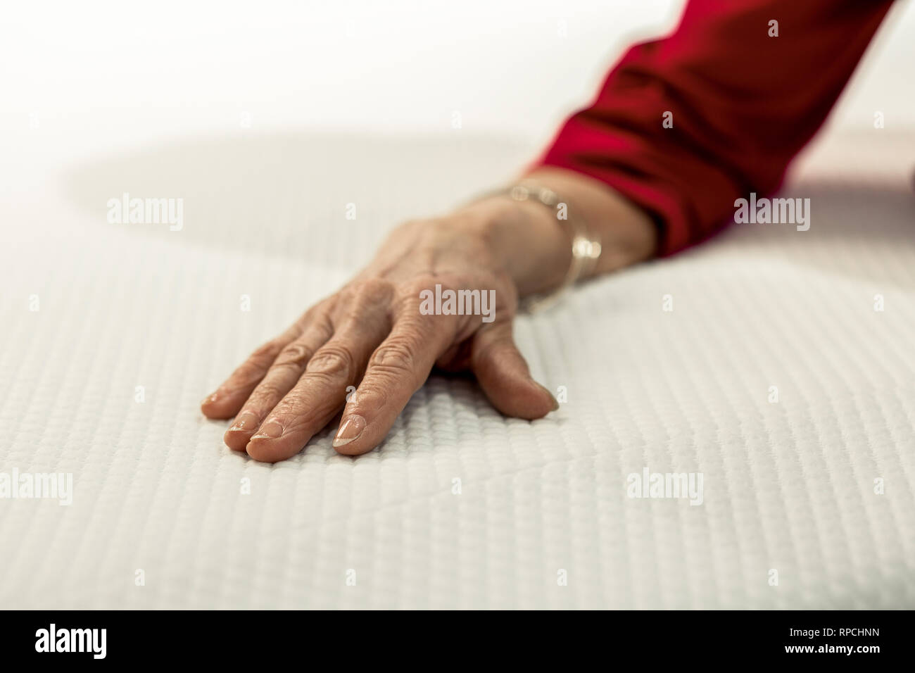 Photo en gros plan d'une femme âgée part sur le lit vêtements Banque D'Images