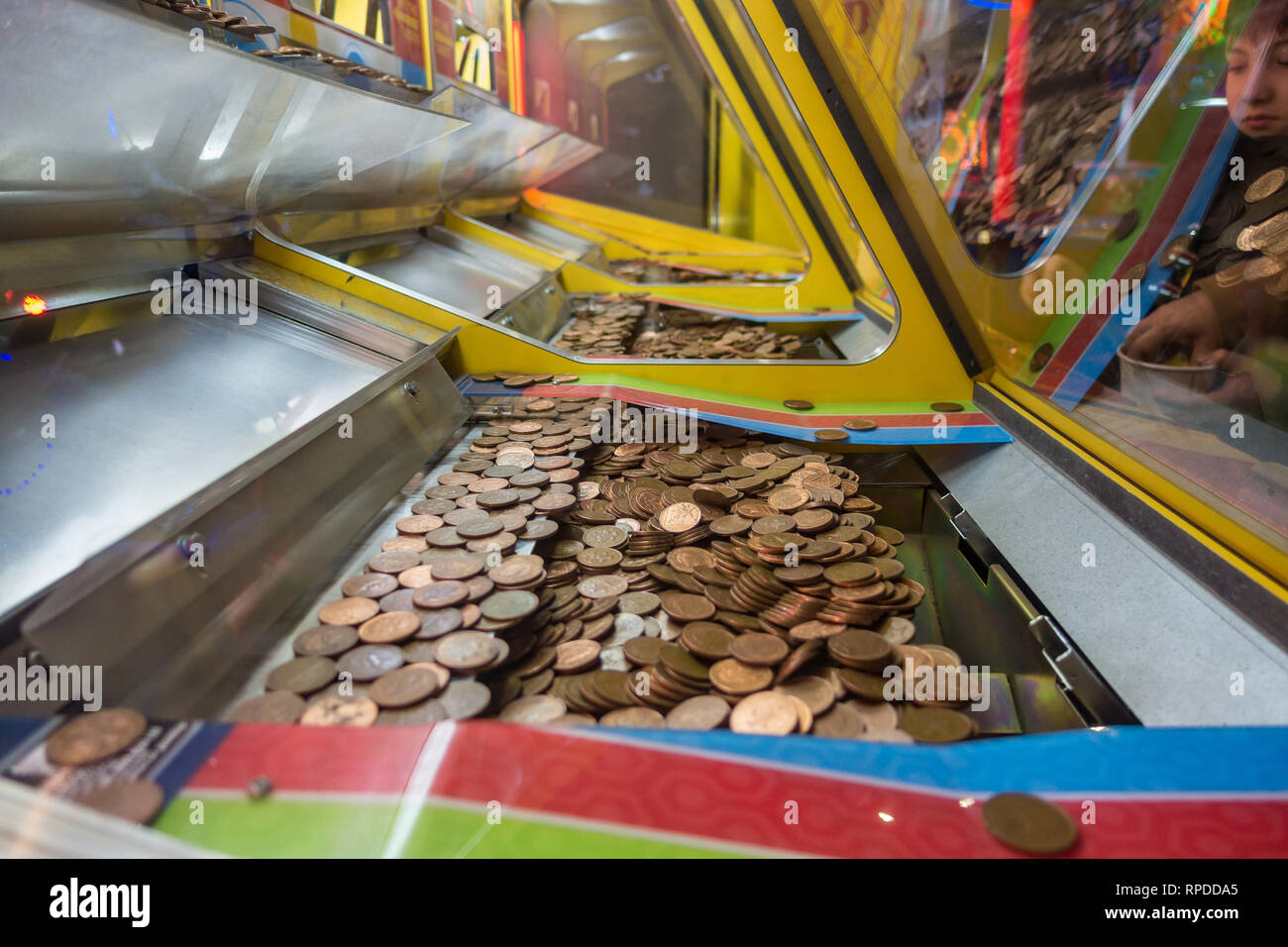 Un jeu de deux chutes penny où deux pence pièce de monnaie équilibre précaire sur le bord d'une tablette inférieure en attente d'être arrachée et a gagné. Banque D'Images