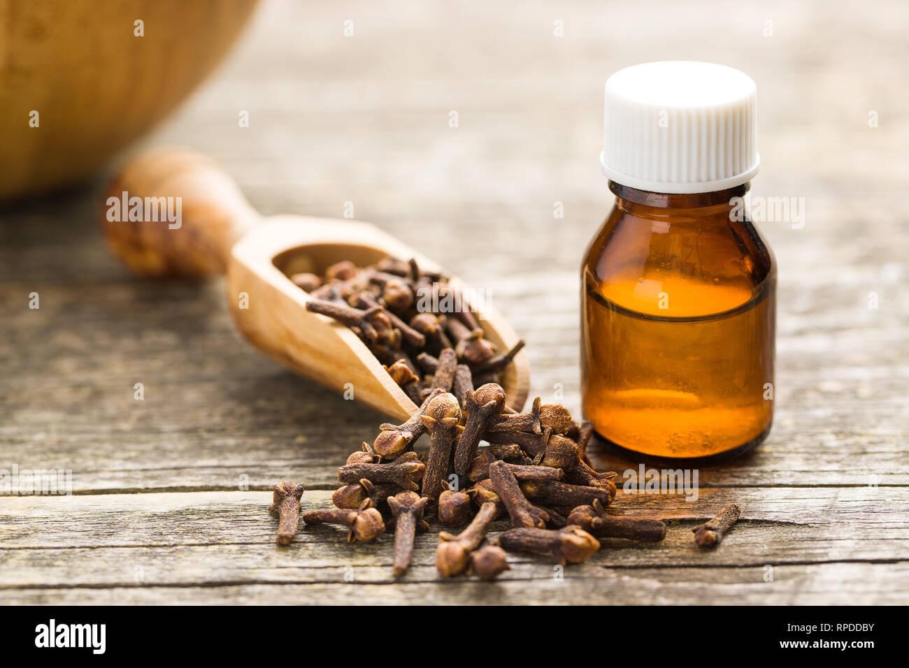 L'huile essentielle de girofle et de girofle spice sur table en bois. Banque D'Images