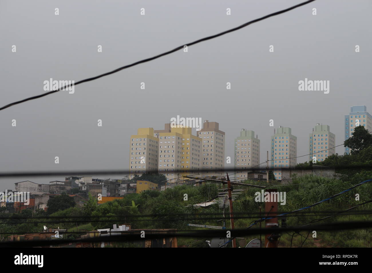 Paysage urbain d'un jour nuageux et pluvieux vu d'une fenêtre. Banque D'Images