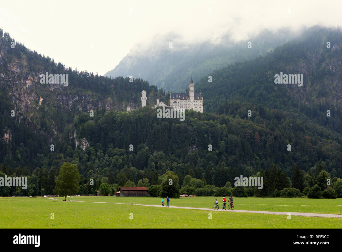 SCHWANGAU - cyclistes avec le célèbre château de Neuschwanstein en arrière-plan. Banque D'Images